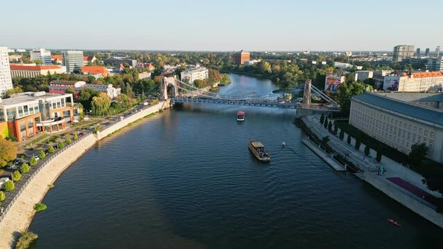 Aerial drone video of the Grunwald Bridge or Most Grunwaldzki and the Oder river in city center of Wrocław in Poland during golden hour