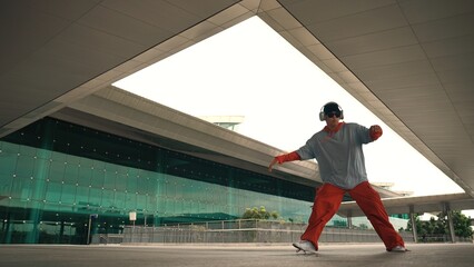 Motion shot of professional hipster listening music while perform freestyle dance. Street dancer...