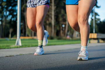 Low angle view of the legs from unrecognizable women jogging and enjoying vitality in the park at...
