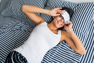 pretty sexy woman lying in bed in morning, wake up early, sleeping in mask