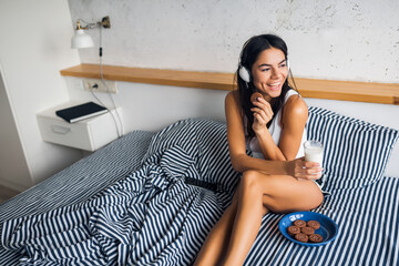 pretty sexy smiling woman sitting in bed in morninga