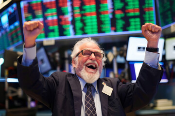 Professional businessman celebrating success raising fists happy about financial bank market growth