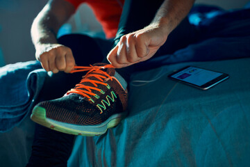 Man tying running shoes before workout