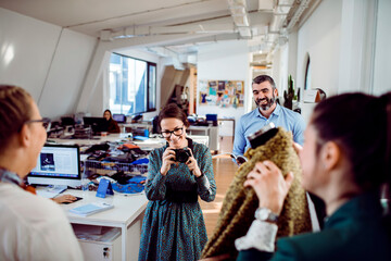 Fashion designers reviewing a clothing sample in a modern studio workspace