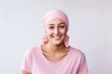 Optimistic young woman with cancer wearing headscarf on white background. Girl after chemotherapy treatment. Oncology patient battling with tumor. World cancer day. Healthcare and medical concept