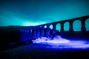 Aqueduct at night illuminated with blue light in arcos del sitio in tepotzotlan state of mexico