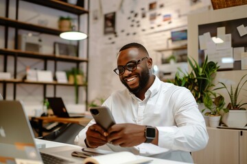 Cheerful afro-american businessman in eyeglasses using smartphone in office