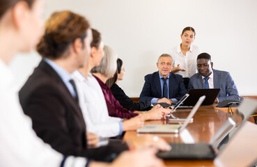 Manager introduces new company executives to colleagues in meeting room