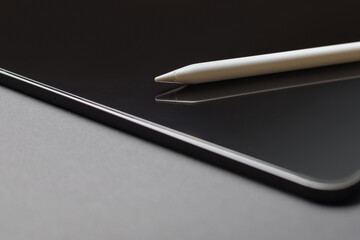 Close-up of digital tablet and pencil on grey background