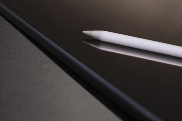 Close-up of digital tablet and pencil on black background