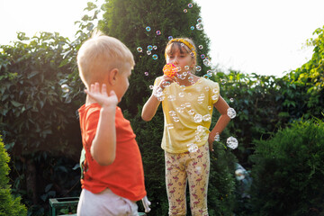 Playing, garden and children blowing bubbles for entertainment, weekend and fun activity together....