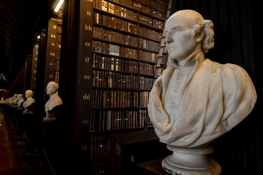 Long Room at Trinity College’s Old Library in Dublin, Ireland. Legal deposit or copyright library. Enormous collection of old books. Marble bust of Humphrey Lloyd and other writers.