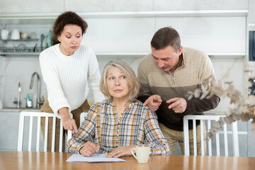 Old woman deciding and signing inheritance papers in family circle