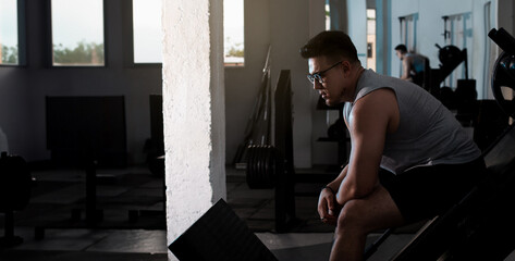 gym lifestyle: young man rests his routine looking at the horizon. copy space