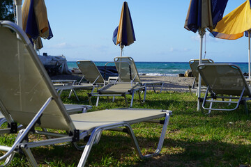 sun beds and beach umbrellas in Argassi beach in Zakinthos , Greece