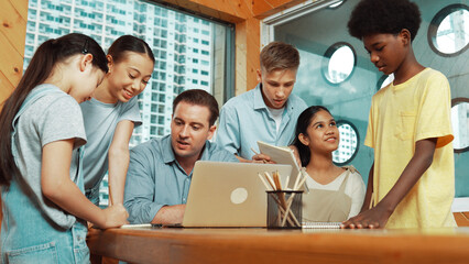 Caucasian teacher giving comment or advise student while smart bot pointing at laptop screen at...