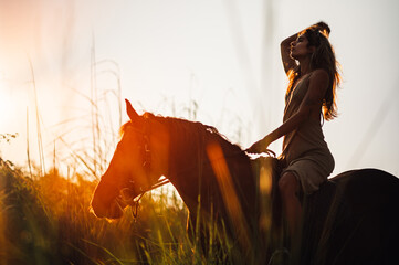 Beautiful woman taking a romantic horse ride along a grassy shoreline