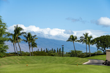 View of the solar powered tsunami warning siren from the tee box on a tropical golf course, palm...
