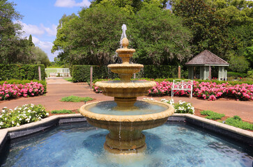 A four tied water fountain in a garden setting