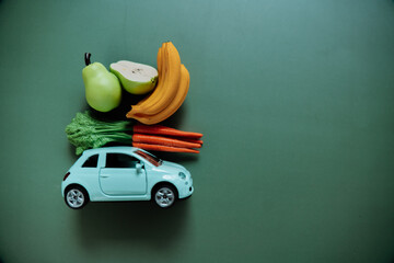 groceries online and delivered to their doorstep. blue car with with fruits and vegetables on a...