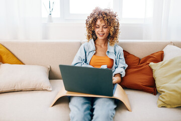 Smiling woman working with laptop in cozy, modern living room