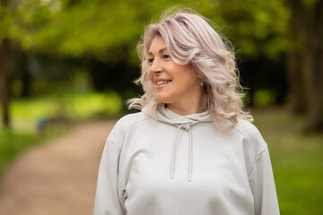 Woman with silver hair smiling in the park