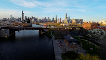 Fototapeta premium fpv aerial drone footage of a urban city neighborhood in Chicago during a clear sky day. the the drone is moving down the street navigating through the trees to do a 180 turn towards downtown.