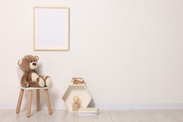 Beautiful children's room with light wall, furniture and toys, space for text. Interior design
