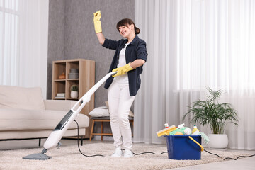 Happy young housewife having fun while cleaning carpet at home
