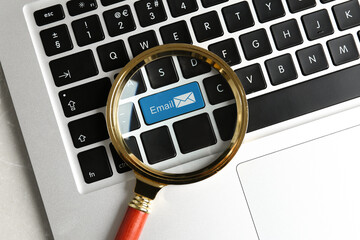 Light blue button with word Email and illustration of envelope on computer keyboard, view through magnifying glass
