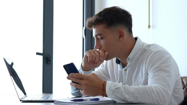 Young man working from home on a laptop in a modern home office, focused and productive, representing remote work, freelance lifestyle, and digital entrepreneurship.