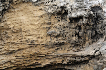 Close up of an eroded rock at a beach textured abstract background