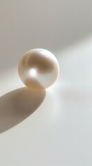 A single, perfectly round pearl floating in a vast expanse of empty white space
