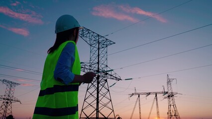 Distribution and supply of electricity. Energy business. Woman engineer, power engineer checks...