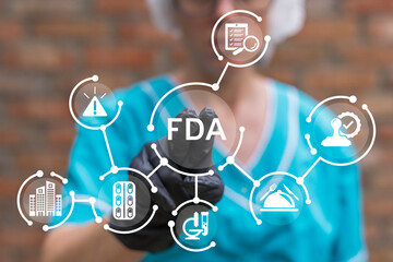 Doctor working on virtual touch screen presses abbreviation: FDA. Food and Drug Administration (...