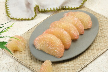 Fresh Peeled Pomelo (Jeruk Bali), Grapefruit or Shaddock on a Plate,White Background