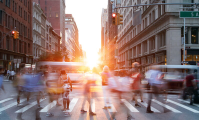 People and traffic in motion crossing the busy intersection of 5th Avenue and 23rd Street in New...