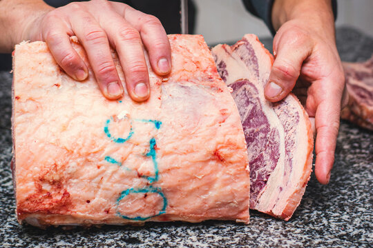 Carnicero cortando costeleta de carne argentina, corte fino para comida cacera del hogar