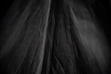 Black crumpled fabric as a background. Texture, pattern.