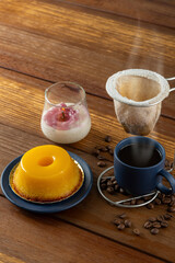 Small quindim, traditional Brazilian sweet, next to a cup of coffee and a candle_9.