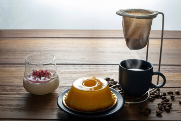 Small quindim, traditional Brazilian sweet, next to a cup of coffee and a candle_12.