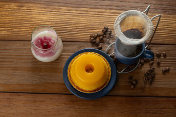 Small quindim, traditional Brazilian sweet, next to a cup of coffee and a candle_16.
