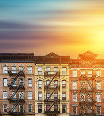 Old apartment buildings in the East Village neighborhood of New York City with colorful sunset sky...