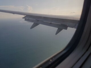 Looking through window aircraft during flight in wing with a nice blue clear sky and beautiful...