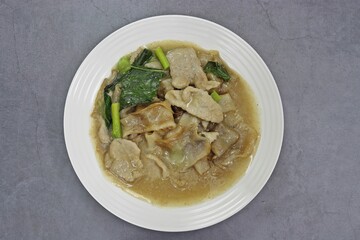 Wide Rice Noodles with Pork in Gravy Sauce, Thai dishes close up top view