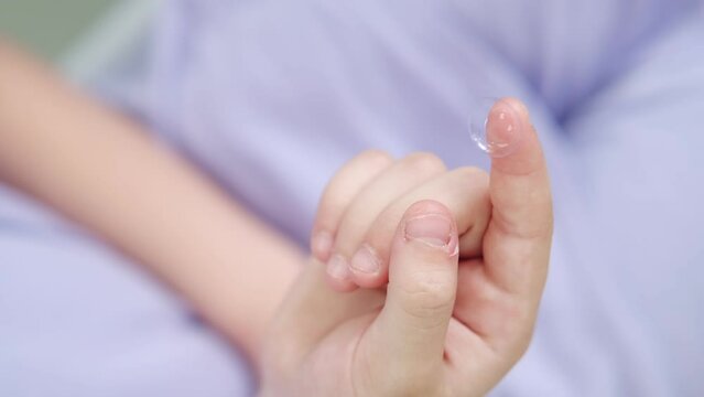 Contact lens close-up on a child's finger. Modern methods of treatment and correction of vision in children. Advertisement for clinics and medical products. Optometry
