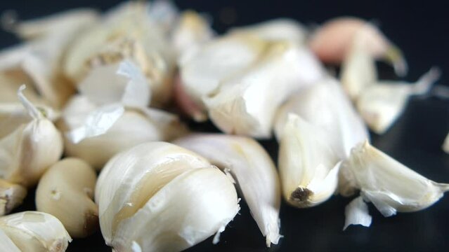 slow motion of garlic drops on a black background,