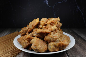 Pile of deep fried pork ribs dressing with flour serving on the plate. Famous appetizer menu in Chinese restaurant.