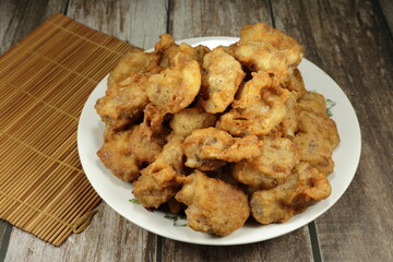 Pile of deep fried pork ribs dressing with flour serving on the plate. Famous appetizer menu in Chinese restaurant.