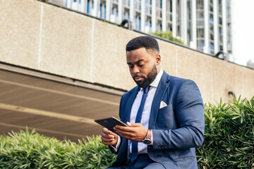 black businessman using a tablet outside
